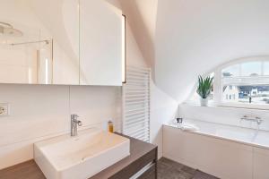 a white bathroom with a sink and a mirror at Ferienhaus Baltic Huus in Zirchow +15 photos