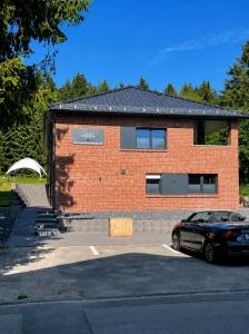 a brick house with a car parked in front of it at Eastside Braunlage in Braunlage