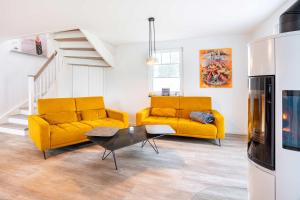 a living room with two yellow couches and a table at Ferienhaus Baltic Huus in Zirchow