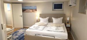a bedroom with a bed with white sheets and pillows at White Coast Villa in Grömitz