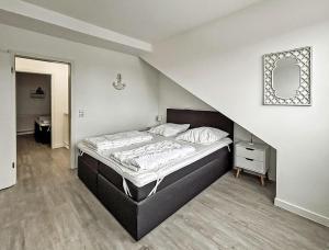 a bedroom with a bed in a room with a staircase at Bugoase in Dranske
