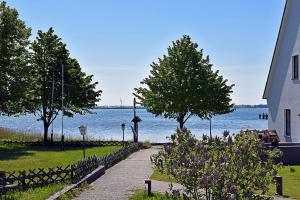 a walkway next to a body of water with trees at Bugoase in Dranske +10 photos