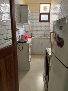 a kitchen with a white refrigerator and a sink at Hakuna matata Apartments in Zanzibar City