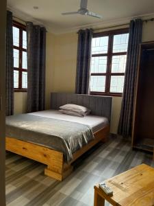a bed in a room with windows and a table at Hakuna matata Apartments in Zanzibar City