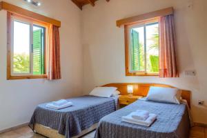 two beds in a room with two windows at Villa Poppy by Villa Plus in Polis Chrysochous +34 photos
