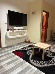 a living room with a flat screen tv and a table at Hakuna matata Apartments in Zanzibar City
