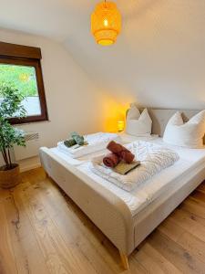 a bedroom with a large bed with white sheets and a window at Landhaus Holly in Frielendorf