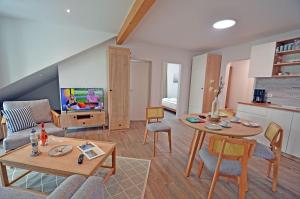 a living room with a table and a tv at Am Ufer Top 13 in Dranske