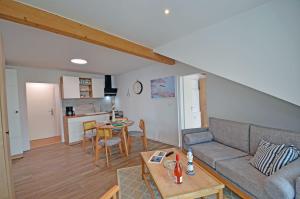 a living room with a couch and a table at Am Ufer Top 13 in Dranske