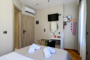 a bedroom with a bed with two white towels at Swan Paradise Nafplio in Nafplio