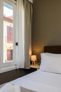 a bedroom with a bed and a window at Swan Paradise Nafplio in Nafplio