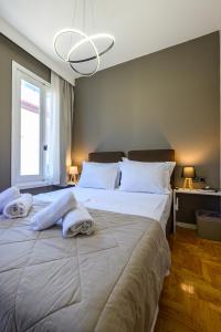 a bedroom with a large bed with towels on it at Swan Paradise Nafplio in Nafplio