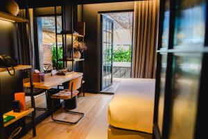ein Schlafzimmer mit Bett, Schreibtisch und Fenster in der Unterkunft Docas Hotel Lisbon in Lissabon + 38 Fotos