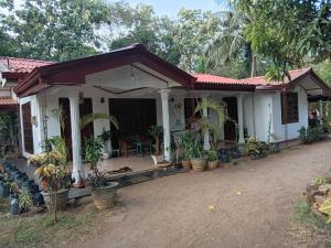 a small white house with a red roof at Elephant safari Lodge sigiriya junction in Habarana