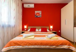 a red bedroom with a bed with red walls at Studio 3 apartmani Braut in Kornić
