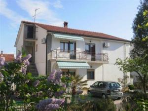 a house with a car parked in front of it at Studio 3 apartmani Braut in Kornić