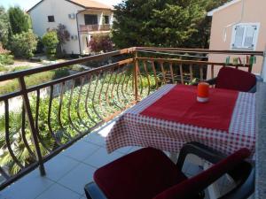 a table on a balcony with a red and white checkered table cloth at Studio 3 apartmani Braut in Kornić