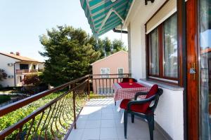 a patio with a table and chairs on a balcony at Studio 3 apartmani Braut in Kornić +1 photo