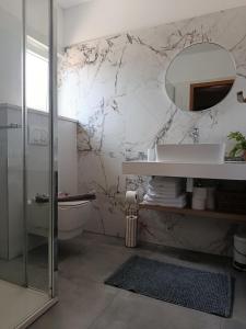 a bathroom with a sink and a toilet and a mirror at Apartments Paloc - Yellow in Bol