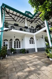 a large white house with a pergola at Mino Villa Kandy in Kandy