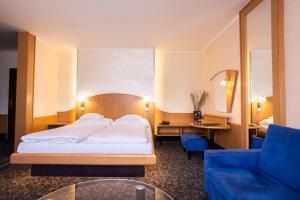 ein Hotelzimmer mit einem Bett und einem blauen Sofa in der Unterkunft Hotel Eroplán in Rožnov pod Radhoštěm + 37 Fotos