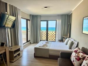 a bedroom with a bed and a view of the ocean at Teos Apartments Primorsko in Primorsko