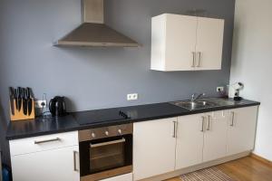 a kitchen with white cabinets and a sink at LE PARADIS ATHOIS in Ath