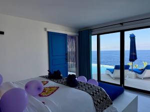 a bedroom with a bed and a view of the ocean at NEW! 2BR Ocean View, Infinity Pool, Villa Kerylos in Sampalan