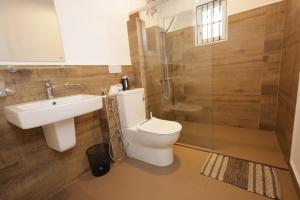 a bathroom with a toilet and a sink and a shower at Mino Villa Kandy in Kandy +35 photos