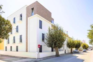 a white building on the side of a street at Casas do Parque - By SCH in São Martinho do Porto