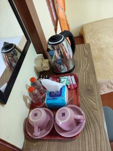 a table with a coffee pot and plates on it at Ghaniya Homestay in Bonto