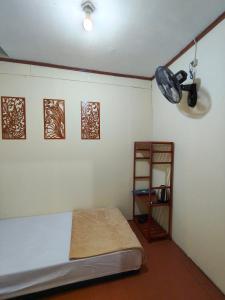 a room with a bed and a shelf in it at Ghaniya Homestay in Bonto