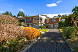 a brick house with a driveway at Springfield bliss with Lake view in Rotorua