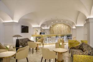 a lobby with tables and chairs and a bar at Hotel Shangri-La Roma by OMNIA hotels in Rome