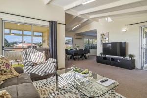 a living room with a couch and a tv at Springfield bliss with Lake view in Rotorua