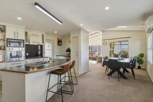 a kitchen and living room with a table and chairs at Springfield bliss with Lake view in Rotorua