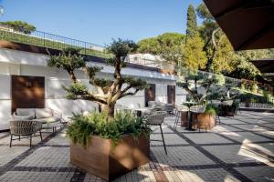 a courtyard with a tree and chairs at Hotel Shangri-La Roma by OMNIA hotels in Rome