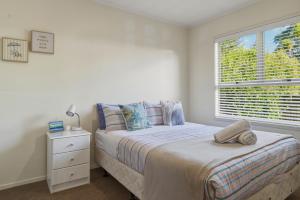 a bedroom with a bed and a window at Springfield bliss with Lake view in Rotorua