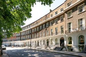 an empty street in front of a large brick building at GuestReady - The Crescent in London