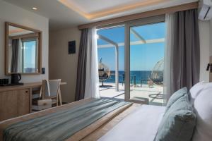 a bedroom with a bed and a view of the ocean at San Marine Beach Hotel, Heart of Chersonissos, Steps from the Sea in Hersonissos