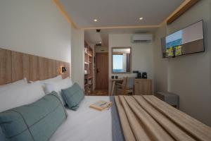 a bedroom with a bed and a tv on a wall at San Marine Beach Hotel, Heart of Chersonissos, Steps from the Sea in Hersonissos