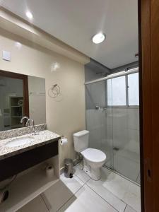 ein Badezimmer mit Toilette und Glasdusche in der Unterkunft Hotel Comoditá Ltda in Sapiranga + 42 Fotos