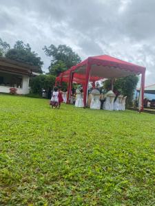 a group of people standing under a red tent at Aradya eco resort in Pundaluoya