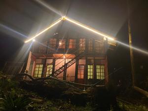 a house with lights on top of it at night at Aradya eco resort in Pundaluoya