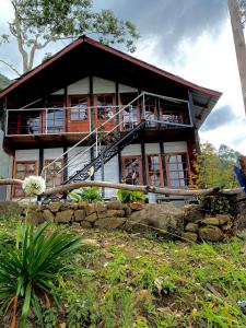 a house on a hill with a balcony at Aradya eco resort in Pundaluoya