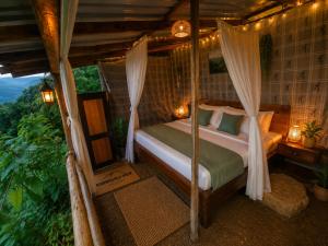a bedroom with a bed with mosquito netting at Aradya eco resort in Pundaluoya