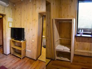 a room with a tv and a room with wooden walls at Царів Хутір in Tsarivka