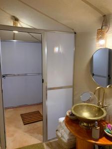 a bathroom with a sink and a mirror at Royal Erg Chebbi Luxury Camp in Adrouine