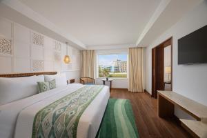 a hotel room with a bed and a flat screen tv at Fortune Beachfront, Puri - Member ITC Hotels' Group in Puri +35 photos