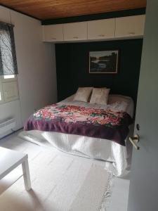 a bedroom with a bed with a blanket on it at puominmutka in Ilomantsi